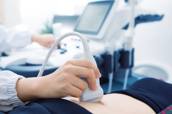 Lekarz wykonujący USG brzucha sondą.