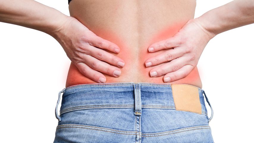 Kobiece plecy z dłońmi opartymi w miejscu bólu nerek.