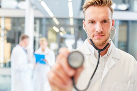 Zdjęcie en face lekarza, który kieruje stetoskop do widza