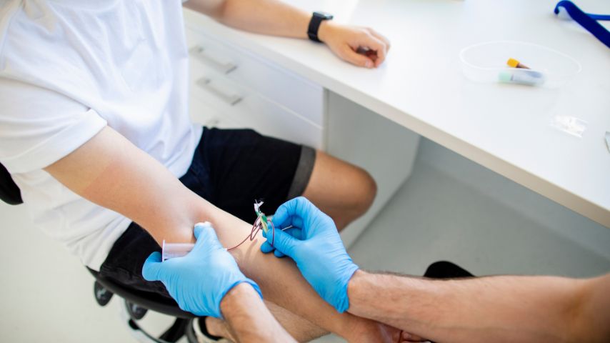 Ujęcie momentu pobierania krwi mężczyzny przez osobę w rękawiczkach.
