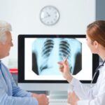 Pulmonolog pokazujący starszej pacjentce obraz płuc na zdjęciu RTG.